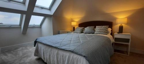 a bedroom with a large bed in a room with windows at Stunning Family Home Sleeps 10 in Dublin