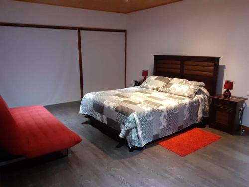 a bedroom with a bed and a red rug at Maria Clara in Navidad