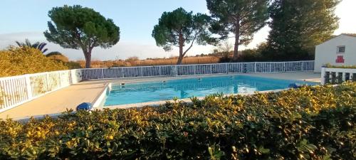 une piscine dans une cour arrière avec une clôture et des arbres dans l'établissement La cabane du pêcheur, à Mèze