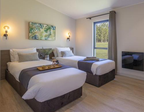 Keld Spring Lodge Retreat في كيركبايمورسايد: غرفة فندقية بسريرين وتلفزيون