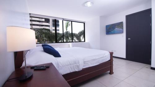 a bedroom with a bed with a desk and a window at Apartamento 104 Bellini, Puerto Santa Ana, Guayaquil in Guayaquil