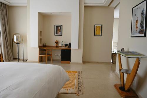 a bedroom with a bed and a table and a kitchen at Maison Kenoosha Boutique Hotel & Spa in Marrakech