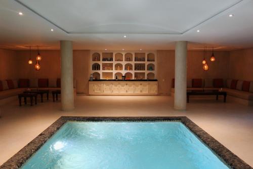 a large indoor pool in a room with columns at Maison Kenoosha Boutique Hotel & Spa in Marrakech