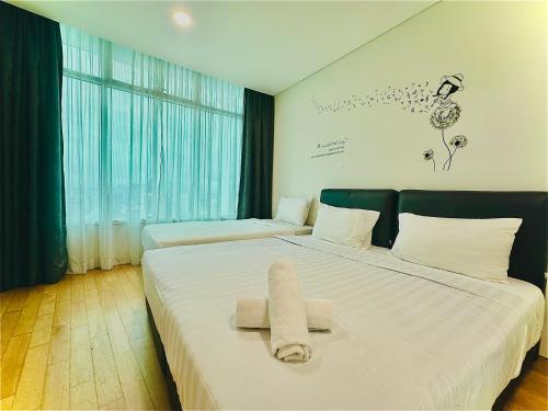 een hotelkamer met 2 bedden en handdoeken erop bij vortex suites klcc Adela Suites in Kuala Lumpur