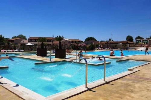 un grupo de personas en una piscina en Maison de vacances plein pied tout confort 200m plage, en Portiragnes