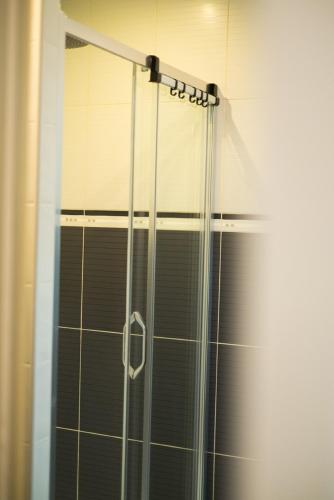 une douche avec une porte vitrée dans une salle de bain dans l'établissement Maison de vacances plein pied tout confort 200m plage, à Portiragnes