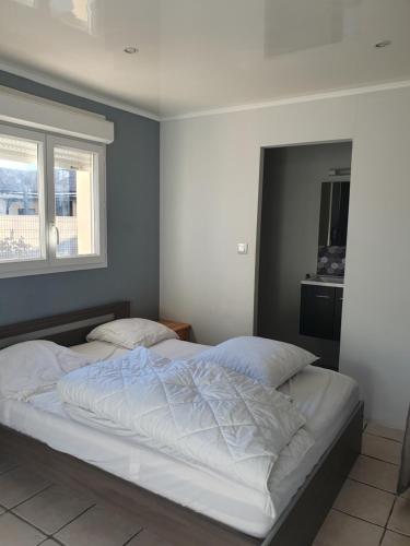 une chambre avec deux lits avec des draps blancs dans l'établissement Maison de vacances plein pied tout confort 200m plage, à Portiragnes