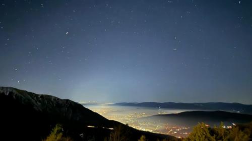 a view of a city at night from a mountain at Planinska kuća "Sedam Vlašića" in Vlasic