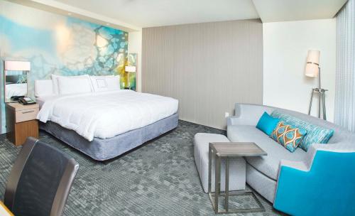 a hotel room with a bed and a couch at Courtyard by Marriott Redwood City in Redwood City
