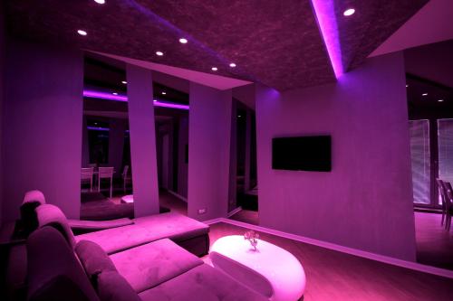 a purple living room with a couch and a tv at Apartments Belgrade in Belgrade