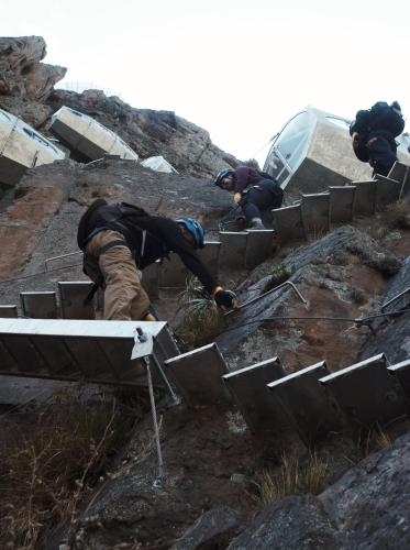a group of people are climbing up a mountain at Starlodge Adventure Suites in Urubamba