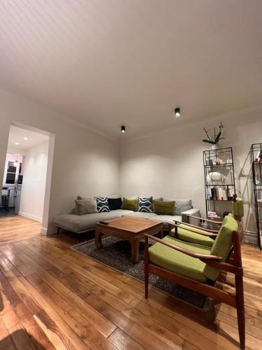 ein Wohnzimmer mit einem Sofa und einem Tisch in der Unterkunft 70m2 Cosy Apartment Daguerre in Paris
