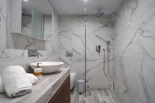 a white bathroom with a sink and a shower at Avra Vip Villa in Paralía Avdhíron