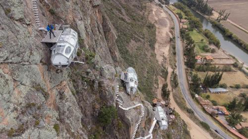 two vehicles are parked on the side of a mountain at Starlodge Adventure Suites in Urubamba