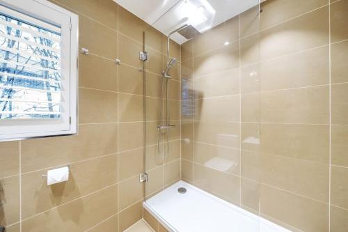 a bathroom with a shower with a toilet and a window at Stylish Contemporary 1 Bed Flat Near London Bridge in London