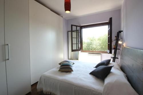 - une chambre avec un lit doté d'oreillers et d'une fenêtre dans l'établissement La casa di Giò: Pesaro mare e cultura, à Bellocchi