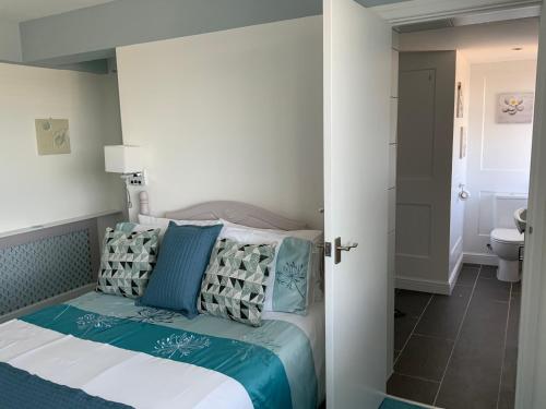 1 dormitorio con 1 cama con almohadas azules y blancas en The Poacher en Stevenage