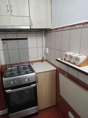 a small kitchen with a stove and white cabinets at Penti Apartament in Suceava