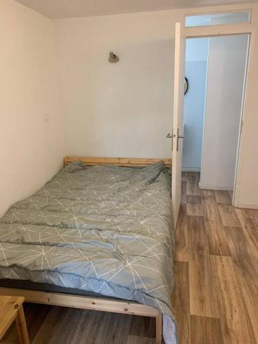 un lit avec un cadre en bois dans une chambre dans l'établissement Magnifique Studio, à Plouvorn