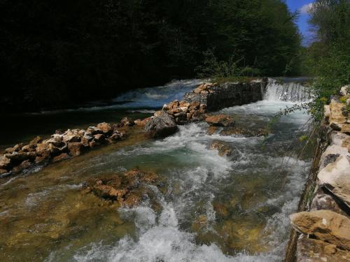 a river with water rushing over rocks and a waterfall at Guesthouse Pavličić in Drežnik Grad