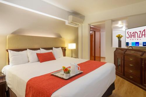Una habitación de hotel con una cama con una bandeja. en Stanza Hotel, en Ciudad de México