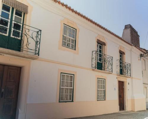 a white building with windows and balconies on it at Casa Cristão Velho in Galveias