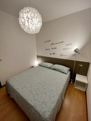 a bedroom with a bed and a chandelier at Case Vacanze Berton Tirano in Tirano