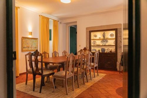 a dining room with a wooden table and chairs at Casa Cristão Velho in Galveias