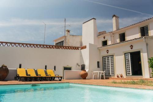 a villa with a swimming pool in front of a house at Casa Cristão Velho in Galveias