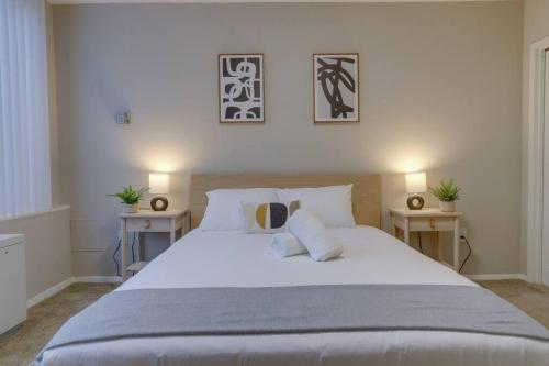 een slaapkamer met een groot wit bed en 2 tafels bij Modern condo at Crystal City in Arlington