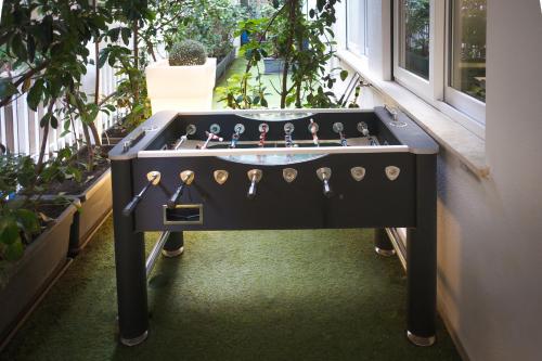 a black foosball table in a room with plants at Hostelò - Luxury Hostel in Palermo