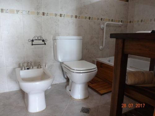 a bathroom with a toilet and a sink at Cabañas & Suites "No es Fácil" in Villa Yacanto
