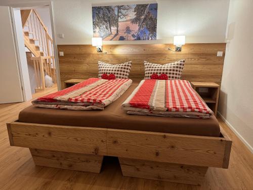 two twin beds in a room with a wooden bed at Villa Herzland Allgäu mit großem Garten und gemütlichem Kaminfeuer inklusive KÖNIGSCARD, Skipass, Bergbahn, Therme inkl in Lechbruck