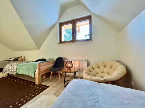 a bedroom with a bed and a chair at Villa Corvo Bianco in Sidzina
