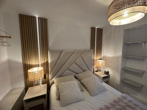 um quarto com uma cama com duas mesas de cabeceira e dois candeeiros em MarbleMood Spa em Obernai