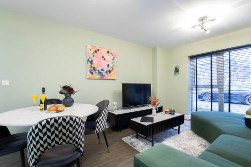a living room with a couch and a dining room at Elliot Oliver - Deluxe Two Bedroom Apartment With Parking & EV Charger in Cheltenham