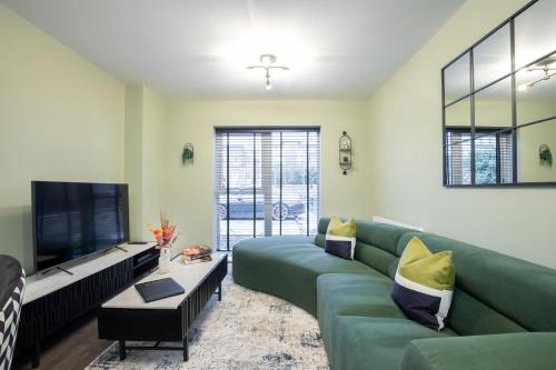 チェルトナムにあるElliot Oliver - Deluxe Two Bedroom Apartment With Parking & EV Chargerのリビングルーム(緑のソファ、薄型テレビ付)