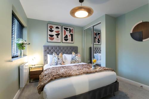 a bedroom with a large bed and a window at Elliot Oliver - Deluxe Two Bedroom Apartment With Parking & EV Charger in Cheltenham