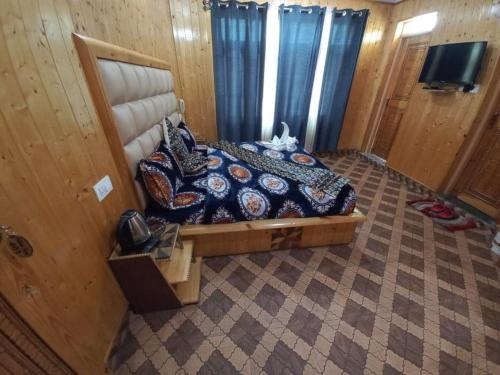 a bedroom with a bed and a tv in a room at Srinagar hotels and houseboats in Srinagar