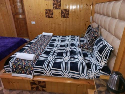 a large bed with pillows on it in a room at Srinagar hotels and houseboats in Srinagar