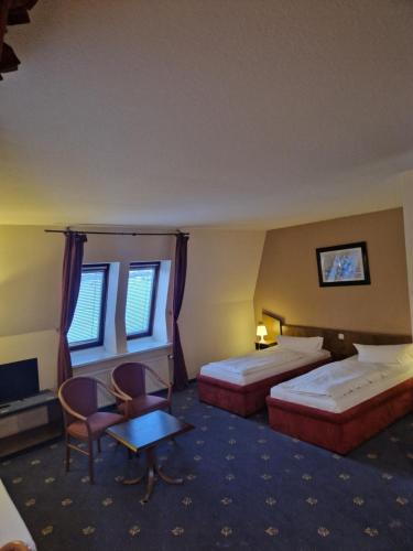 漢堡的住宿－Entrée Glinde Restaurant & Tagungshotel，酒店客房带两张床和一张桌子以及椅子。