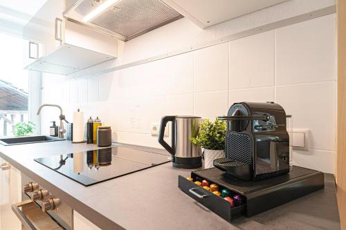 une cuisine avec une cafetière sur un comptoir dans l'établissement Deluxe Flat, PS4, Parken, Netflix, Zentral, à Bendorf