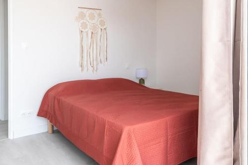 a bedroom with a red bed with a red blanket at La vie en Rose in Narbonne