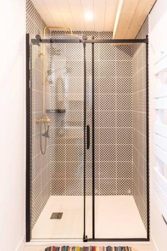 une douche avec une porte vitrée dans une salle de bain dans l'établissement La vie en Rose, à Narbonne
