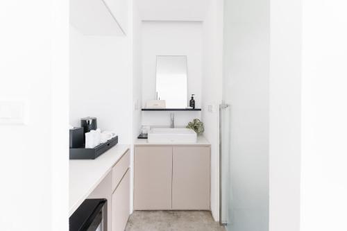 a white kitchen with white cabinets and a sink at Lloyd's Inn Kuala Lumpur in Kuala Lumpur
