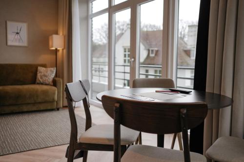 um quarto com uma mesa e cadeiras e uma grande janela em By Friso Den Haag em Scheveningen