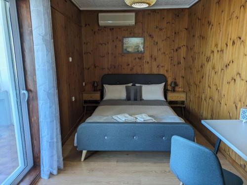 a bedroom with a bed in a room with wooden walls at Sea View Roof Garden in Kiáton