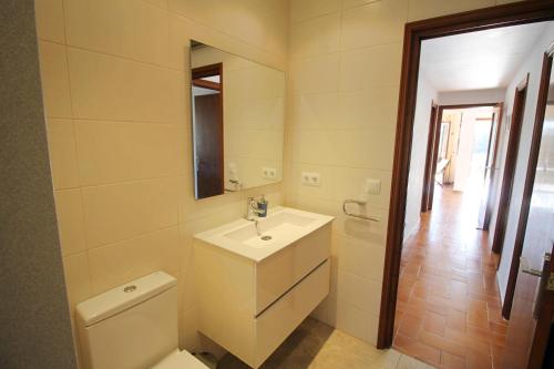 a bathroom with a toilet and a sink and a mirror at Villa Ensueño in Calonge