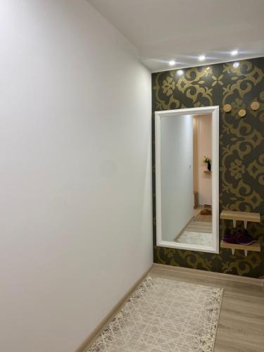 Habitación con espejo y pared con alfombra. en Iskra na Zlataru, en Nova Varoš