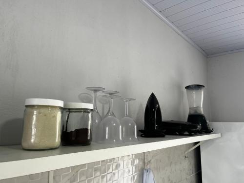 a shelf with glass bottles and other items on it at Casa no Centro (Orla de Marabá) in Marabá